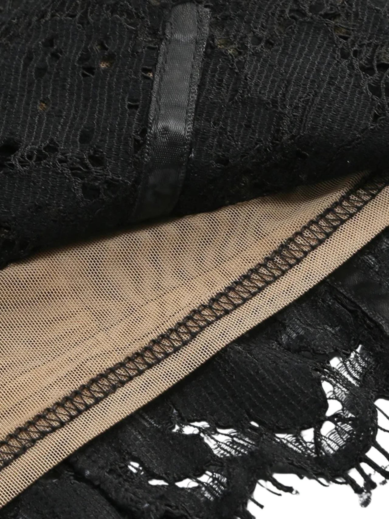 Close-up of black sheer lace  bodycon dress fabric with a nude liner