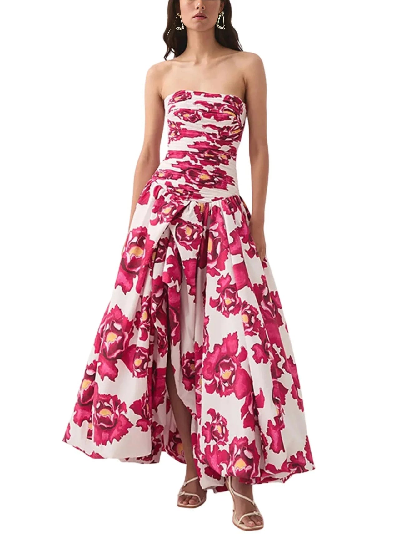 Woman wearing a red floral strapless long bubble dress with a high slit on a white background