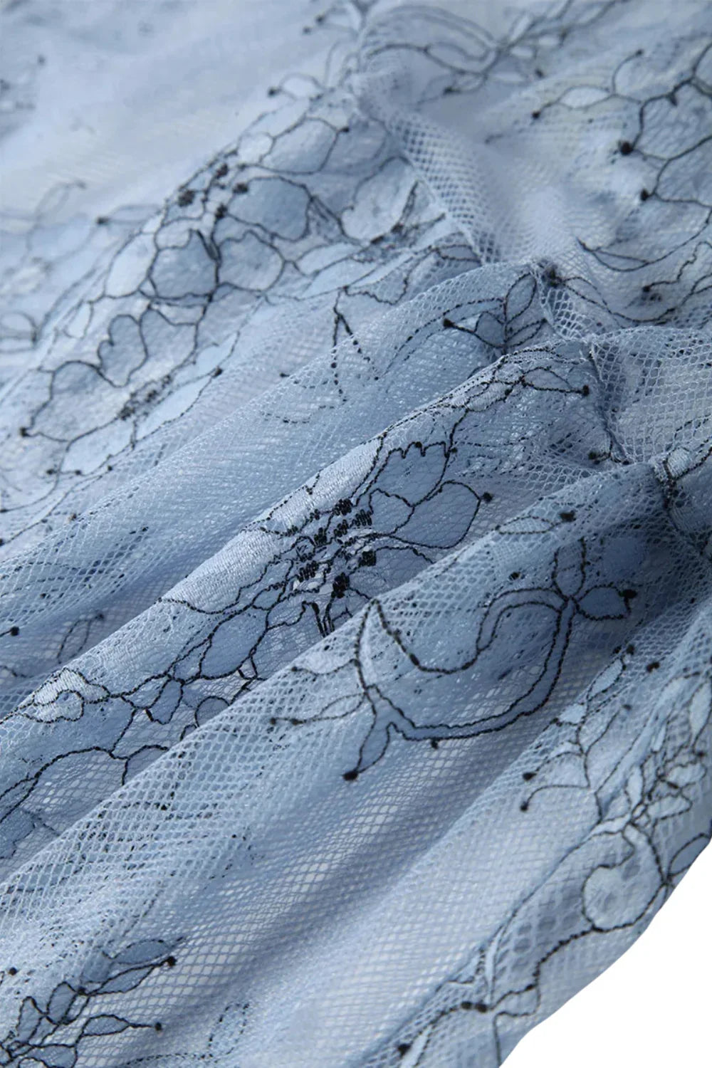 Close-up of blue lace fabric with floral patterns
