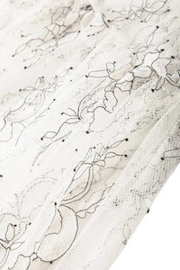 Thumbnail for Close-up of textured lace with abstract black line art on fabric on a white background