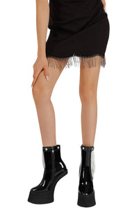 Thumbnail for Person wearing a black fringe skirt and black platform boots on a white background