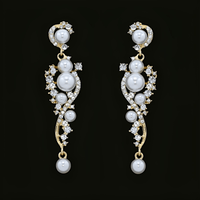 Thumbnail for A pair of bridal earrings featuring a drop design with a cluster of simulated pearls and sparkling rhinestones, with gold plating.