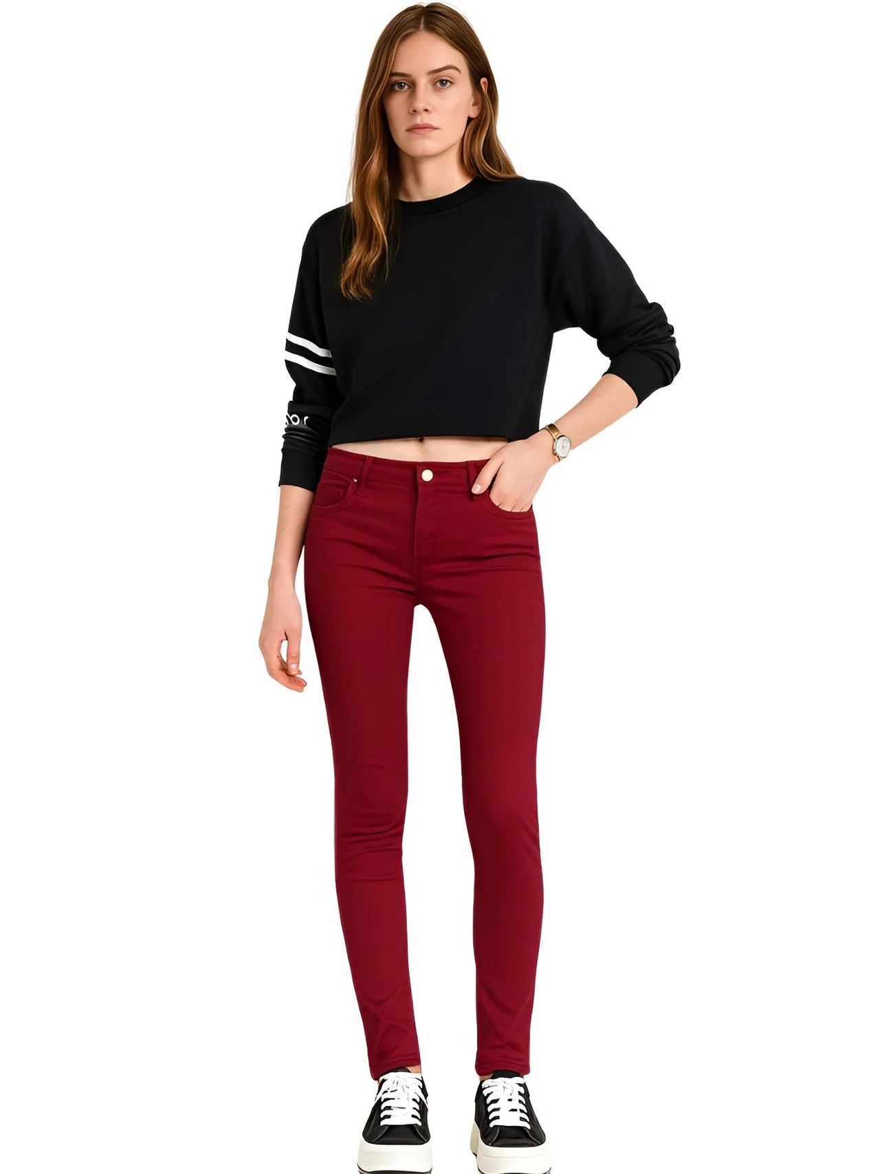 Woman wearing a black cropped sweater and red jeans on a white background