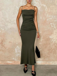 Thumbnail for Woman wearing a green tight dress against a textured wall.