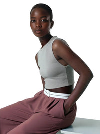 Thumbnail for Woman wearing a gray sleeveless top and maroon pants with a white belt on a white background