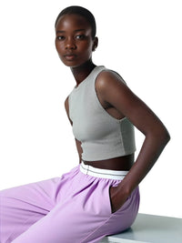Thumbnail for Woman wearing a gray crop top and purple pants on a white background