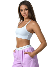 Thumbnail for Woman wearing a white sports bra and purple pants on a white background