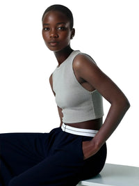 Thumbnail for Woman wearing a gray sleeveless top and black pants on a white background