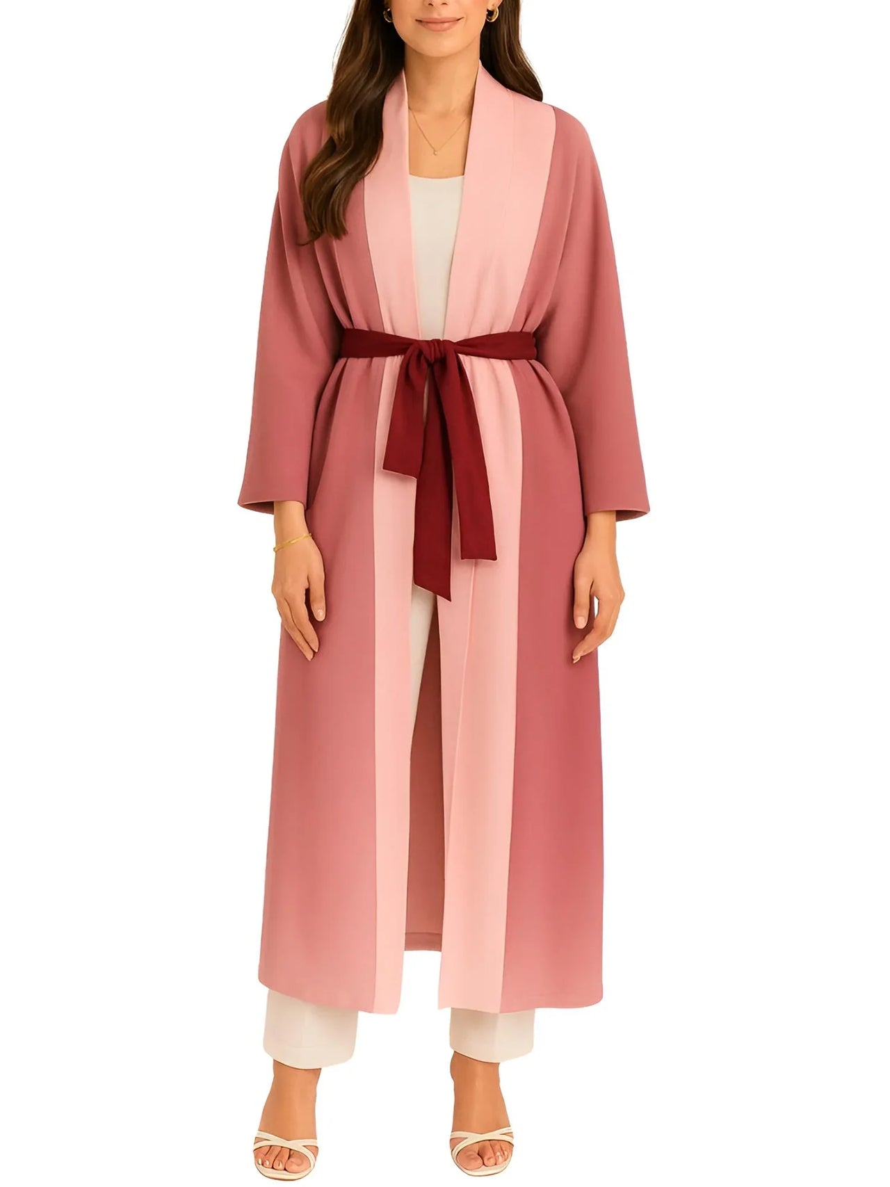 Woman wearing a long pink jacket with a red belt on a white background