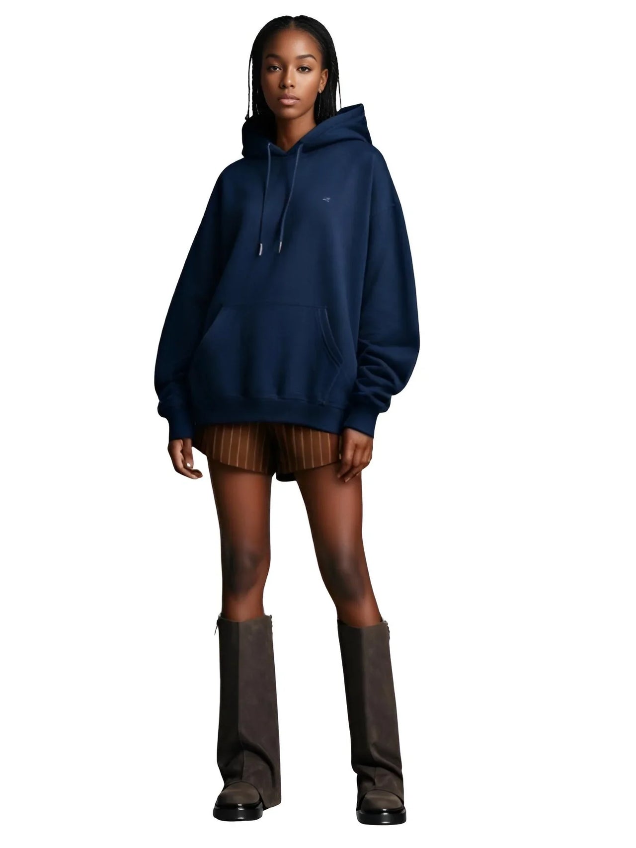 Person wearing a navy blue hoodie and brown slouch boots on a white background