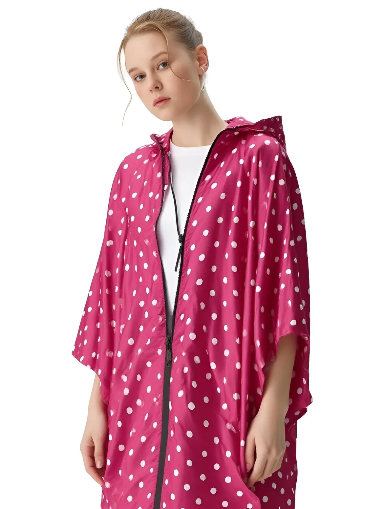 Person wearing a pink polka dot raincoat on a white background