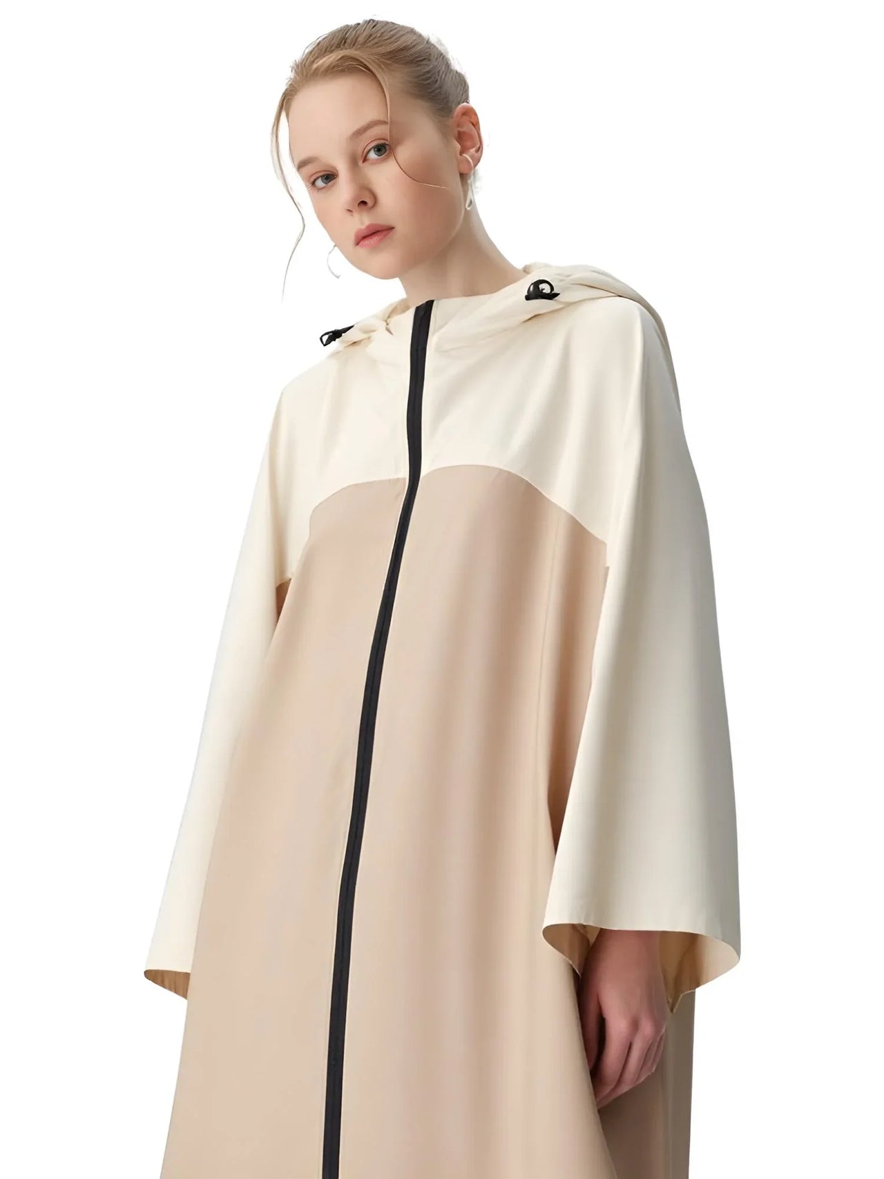 Person wearing a beige and white raincoat with a black zipper on a white background