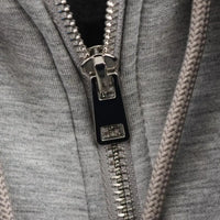 Thumbnail for Close-up of a zipper on a gray garment with a braided texture.