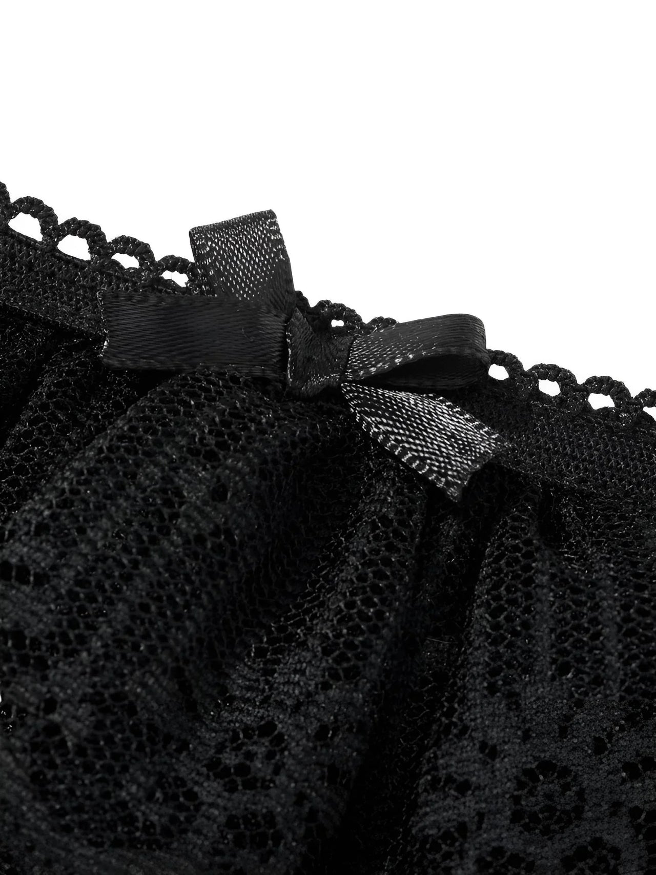 Close-up of black lace fabric with a bow on a white background