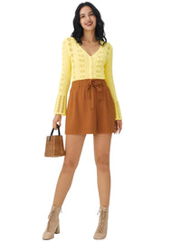 Thumbnail for Woman wearing a yellow crop cardigan and brown skirt holding a woven handbag on a white background