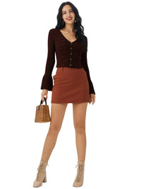Thumbnail for Woman wearing a brown crop sweater and skirt with beige boots, holding a woven bag on a white background