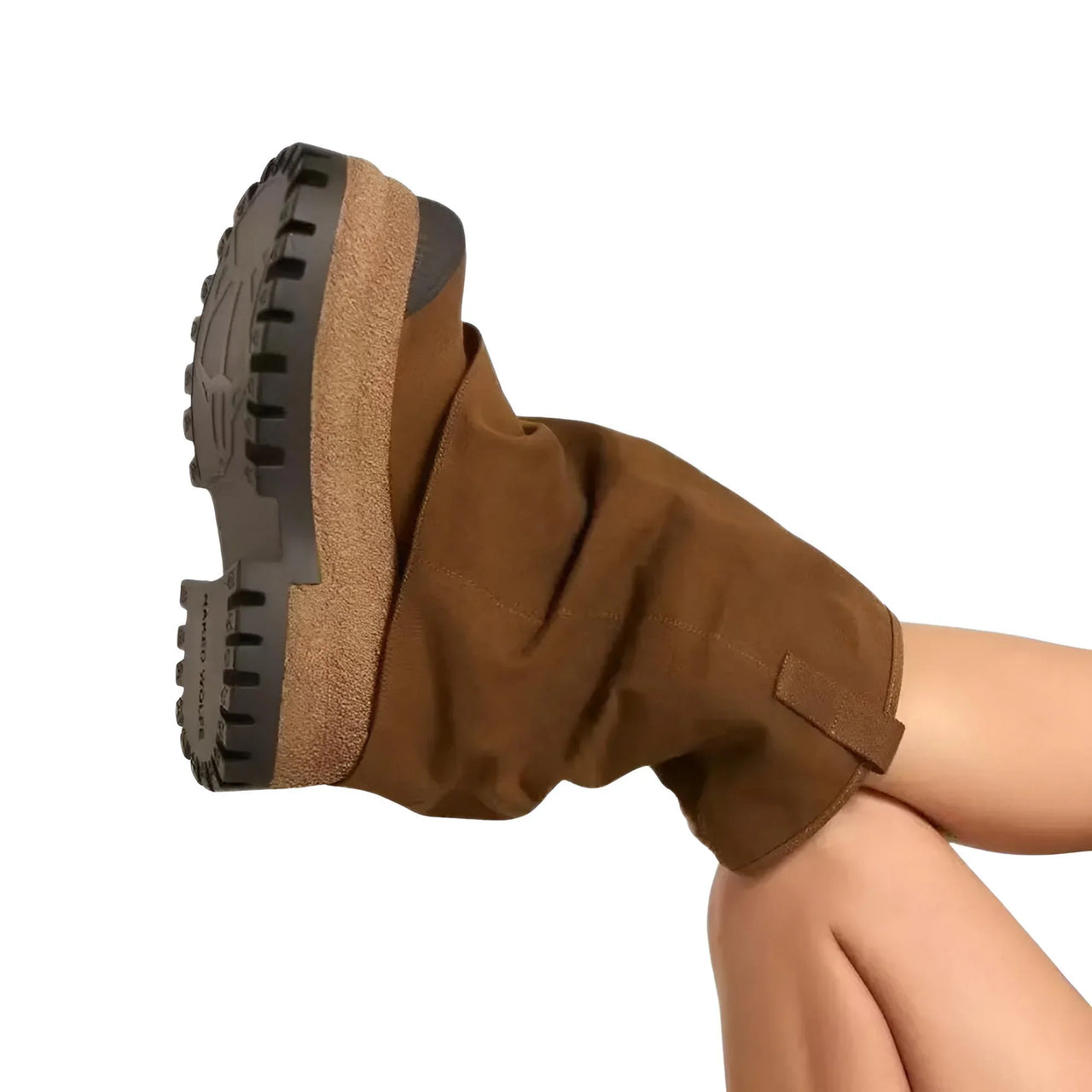 Brown platform slouch boot with a textured sole worn by a woman on a white background