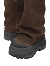 Thumbnail for Brown platform slouch boots with black soles worn by a person on a white background
