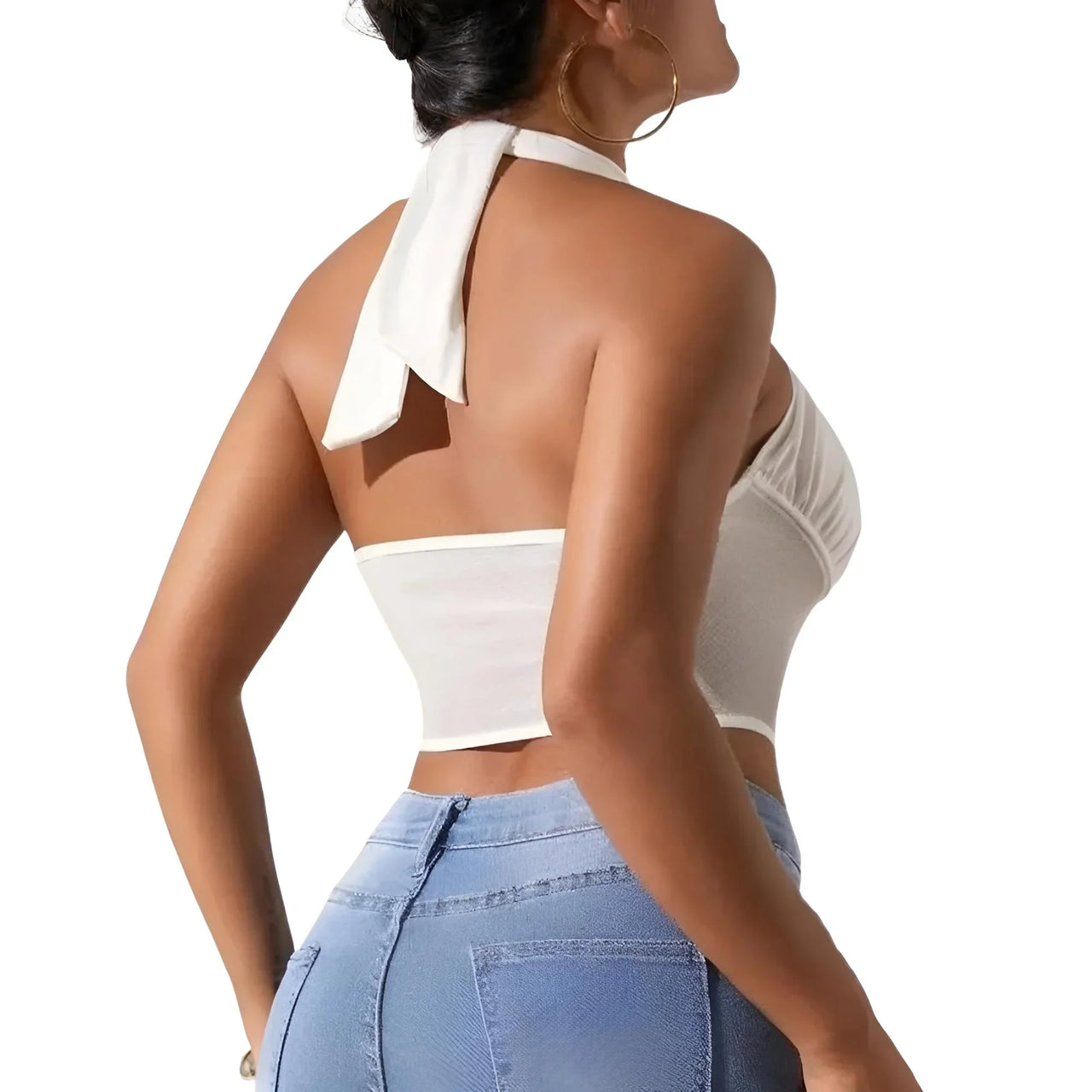 Woman wearing a white halter top and blue jeans on a white background