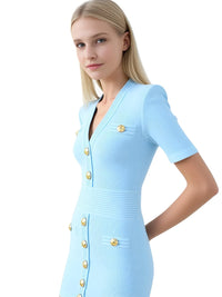 Thumbnail for Woman wearing a light blue dress with gold buttons on a white background