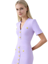 Thumbnail for Woman wearing a light purple dress with gold buttons on a white background