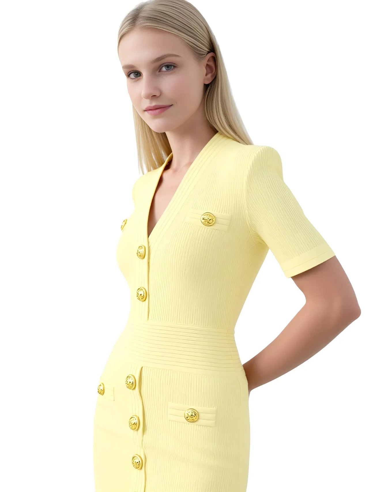 Woman wearing a light yellow dress with gold buttons on a white background
