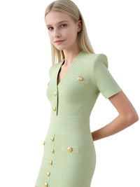 Thumbnail for Woman wearing a light green dress with gold buttons on a white background