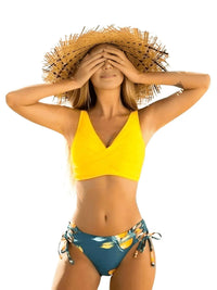 Thumbnail for Woman wearing a yellow bikini top and lemon bottom with a straw hat on a white background