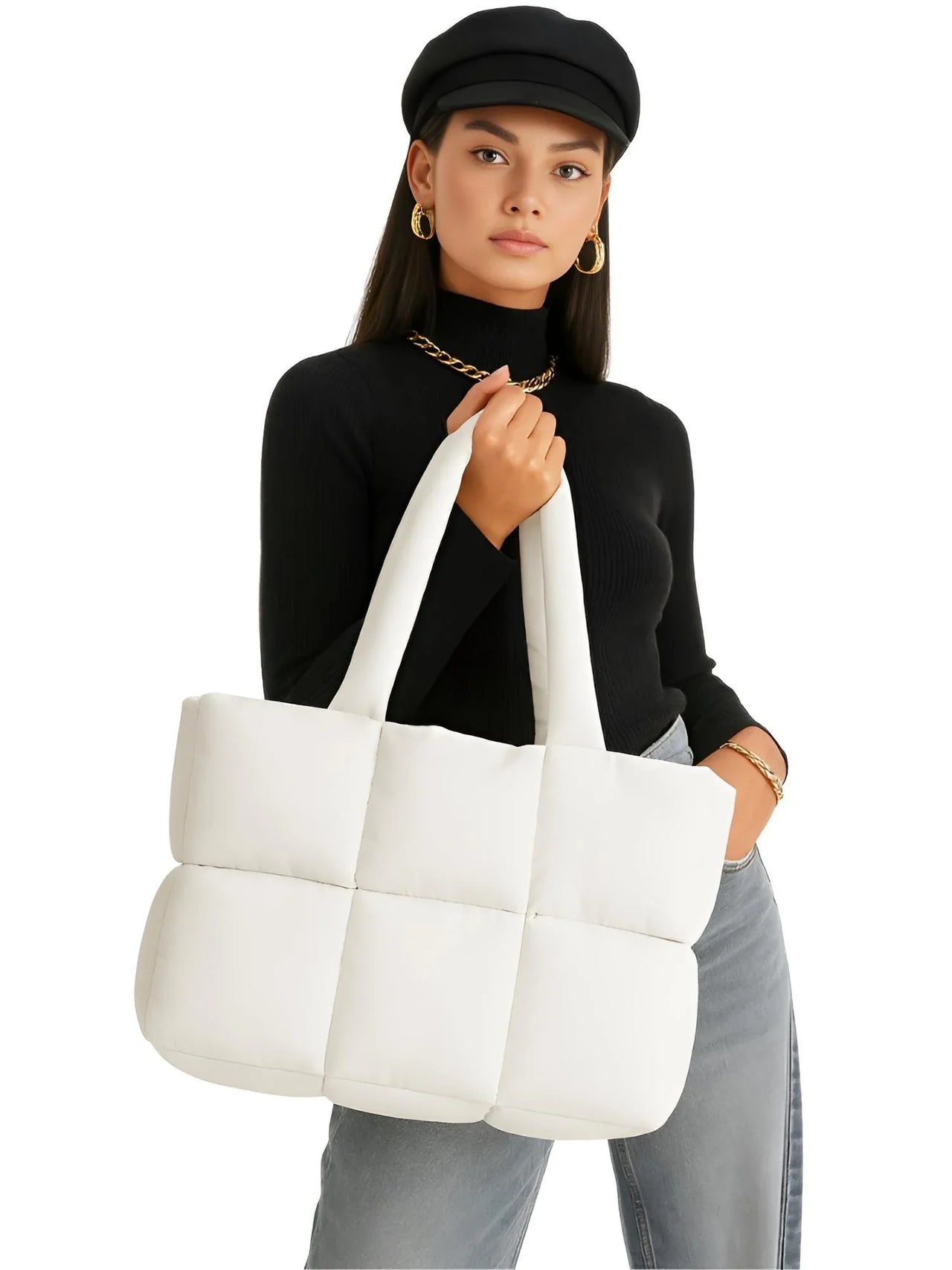 Woman holding a white quilted tote bag against a white background
