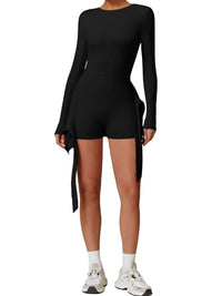Thumbnail for Person wearing a black long-sleeve top and shorts set on a white background
