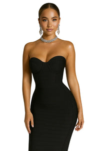 Thumbnail for Woman wearing a black strapless bustier with a black pencil skirt and jewelry on a white background