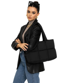 Thumbnail for Woman holding a black puffer bag against a white background
