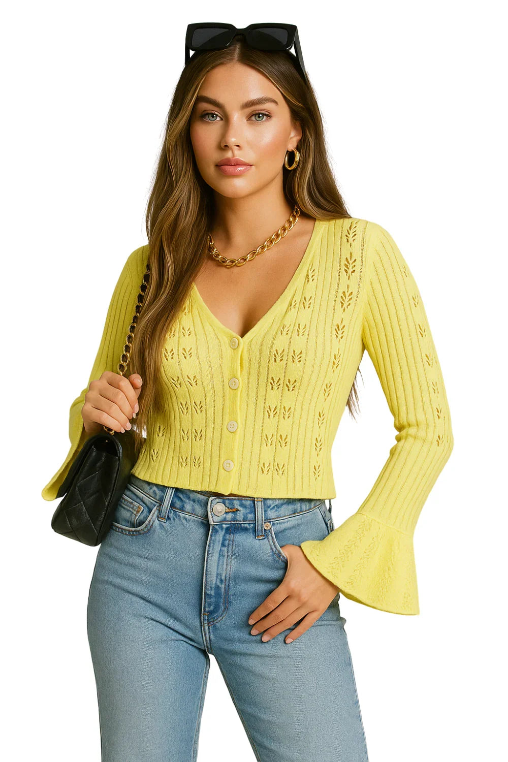 Woman wearing a yellow knitted flare sleeve cardigan and blue jeans on a white background