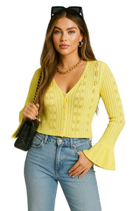 Thumbnail for Woman wearing a yellow knitted flare sleeve cardigan and blue jeans on a white background