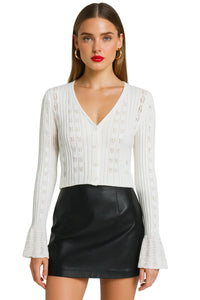 Thumbnail for Woman wearing a white cropped long-sleeve cardigan and black leather skirt on a white background
