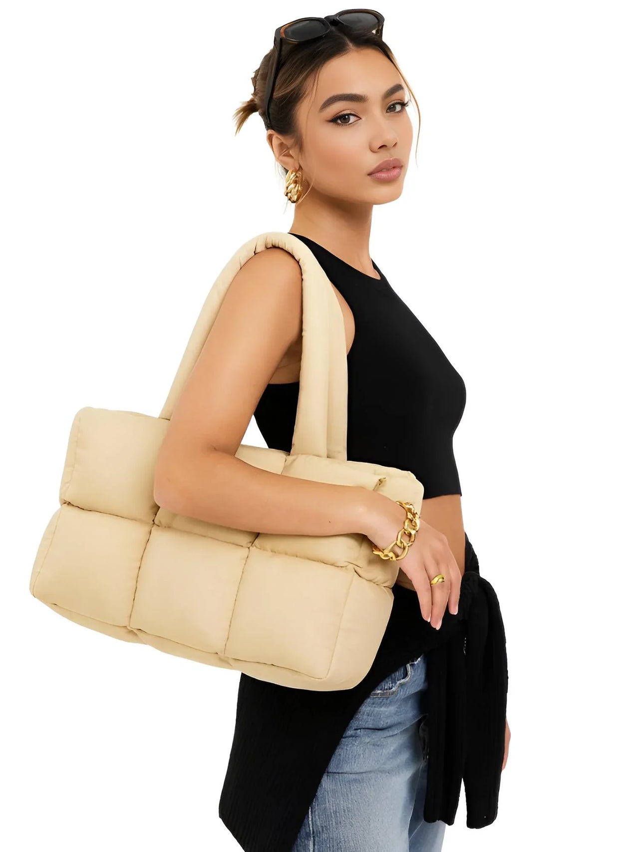 Woman holding a khaki puffer bag against a white background