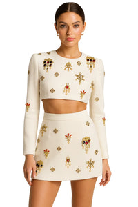 Thumbnail for Woman wearing a white skirt set with decorative rhinestones on a white background