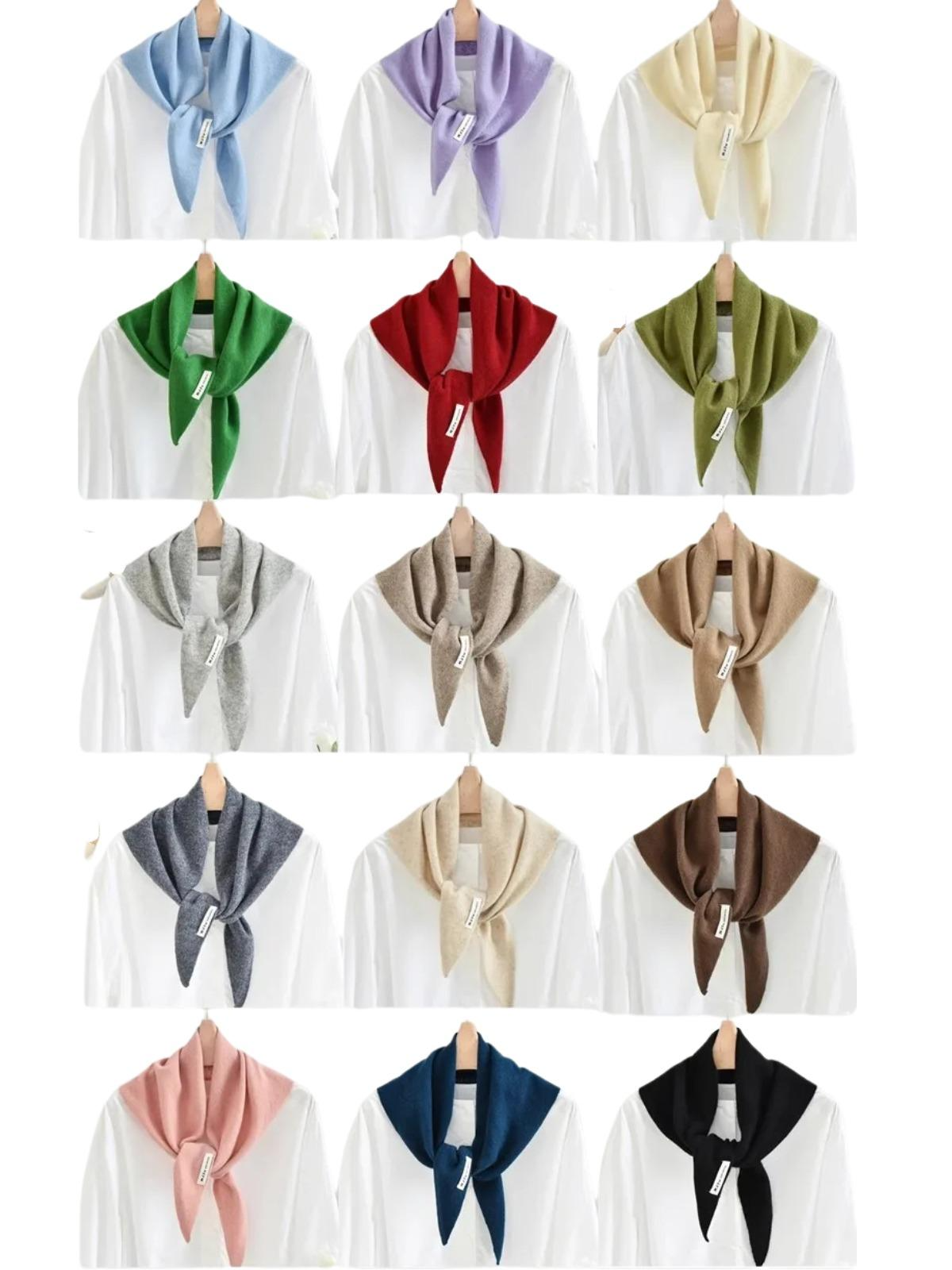 Collection of wool scarves in various colors draped over white shirts on hangers.