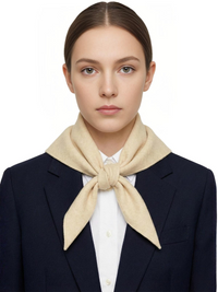 Thumbnail for Woman wearing a beige scarf and navy blazer on a white background