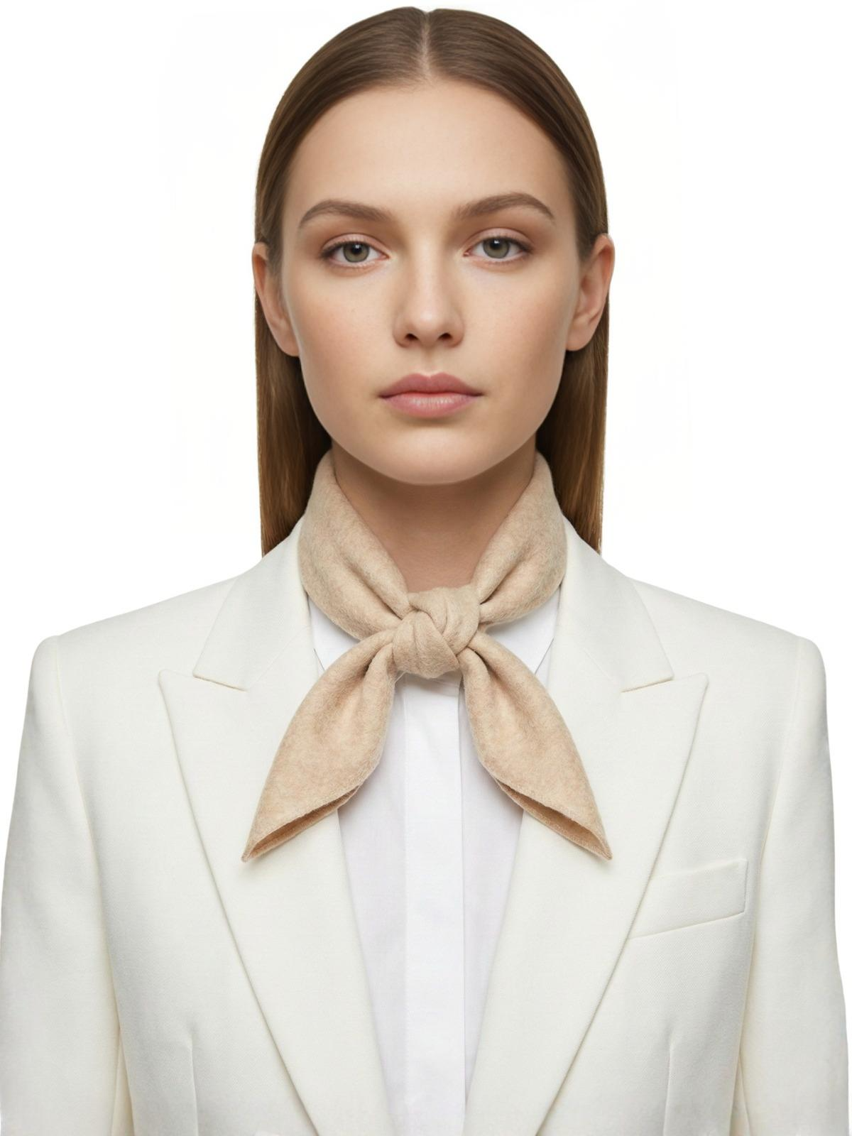 Woman wearing an apricot wool  scarf and white blazer on a white background