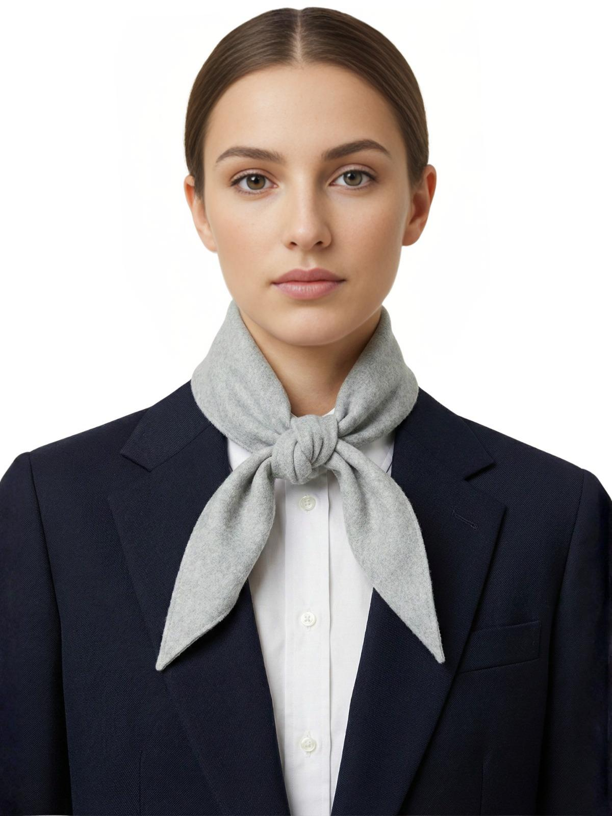 Woman wearing a gray wool scarf around her neck with a white background