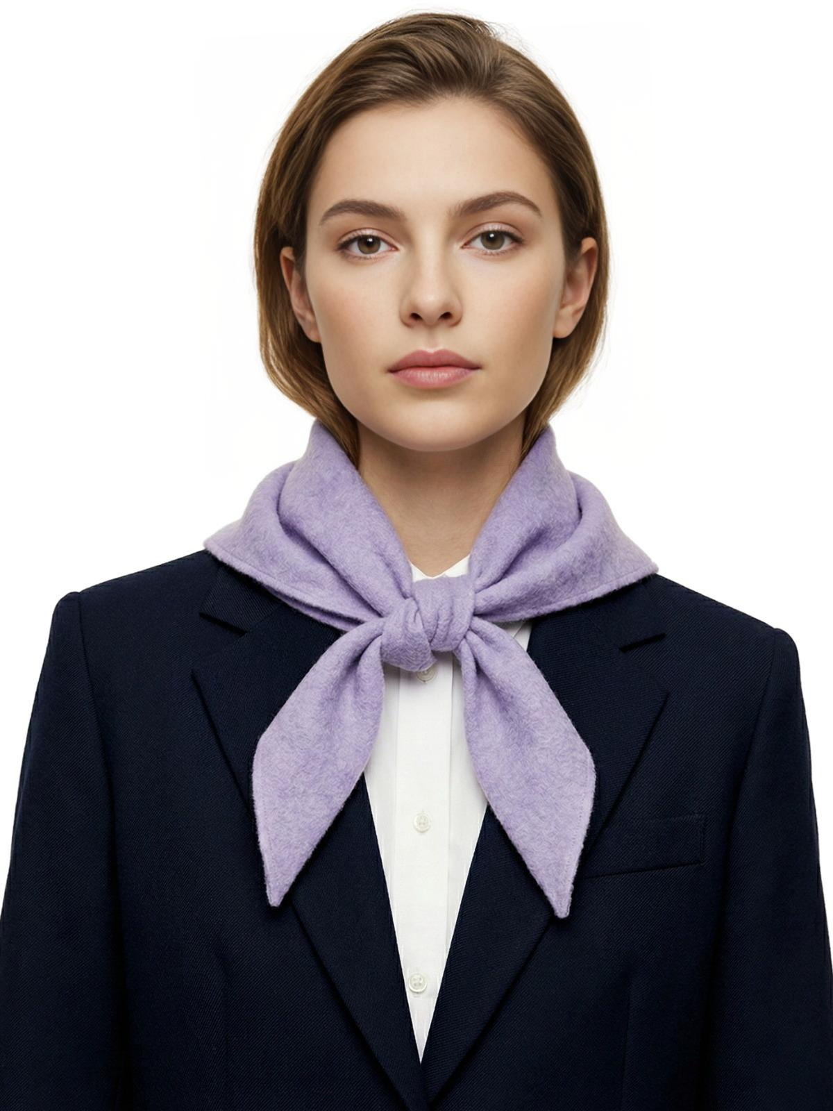 Woman wearing a dark blue coat with a light purple wool scarf on a white background