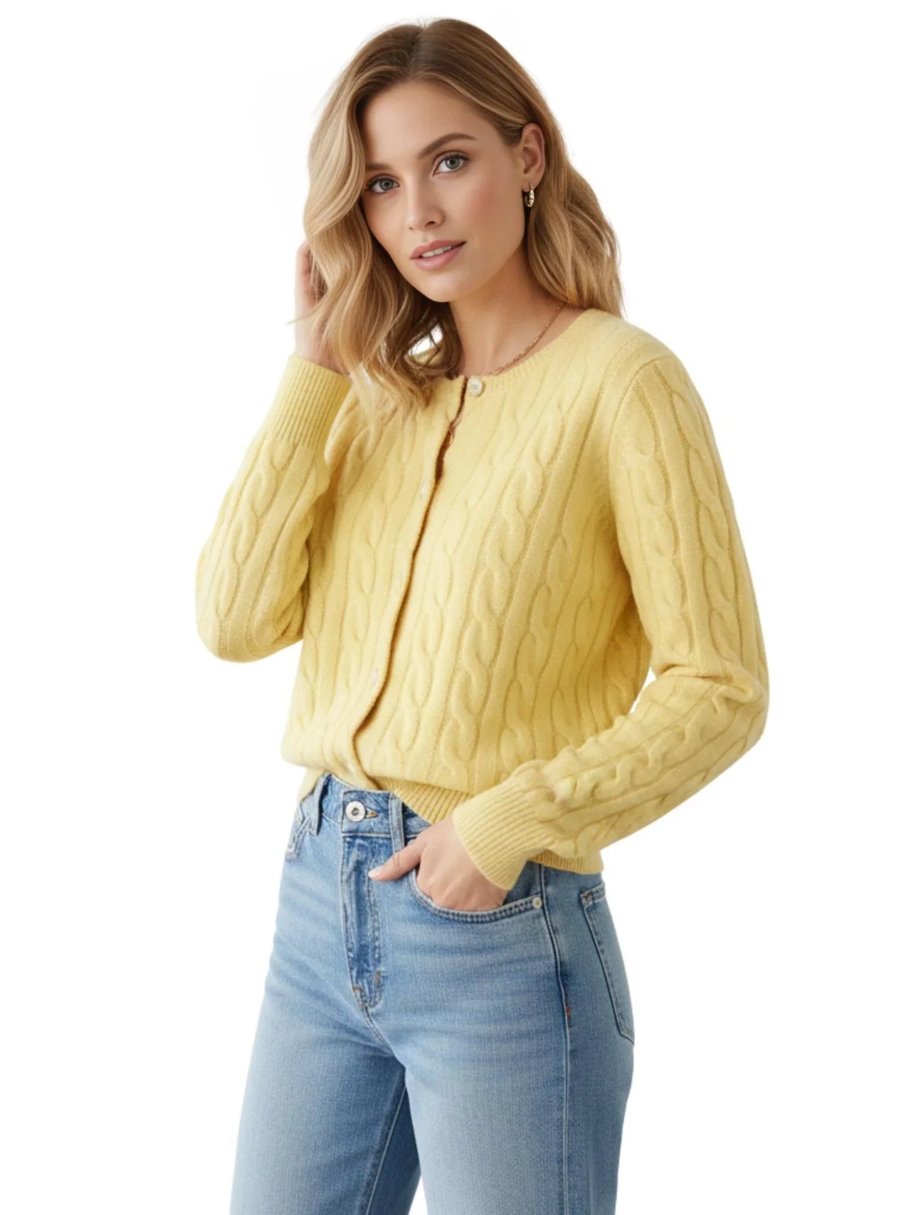 Woman wearing a yellow cable knit cardigan and blue jeans on a white background