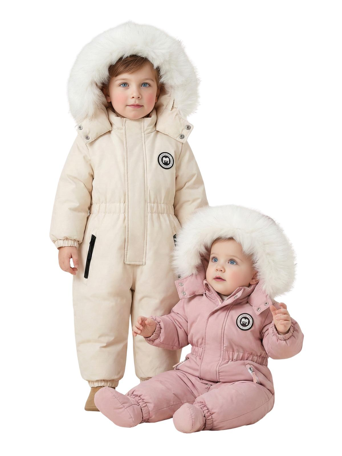 Two children wearing cream and pink snowsuits with fur hoods on a white background.