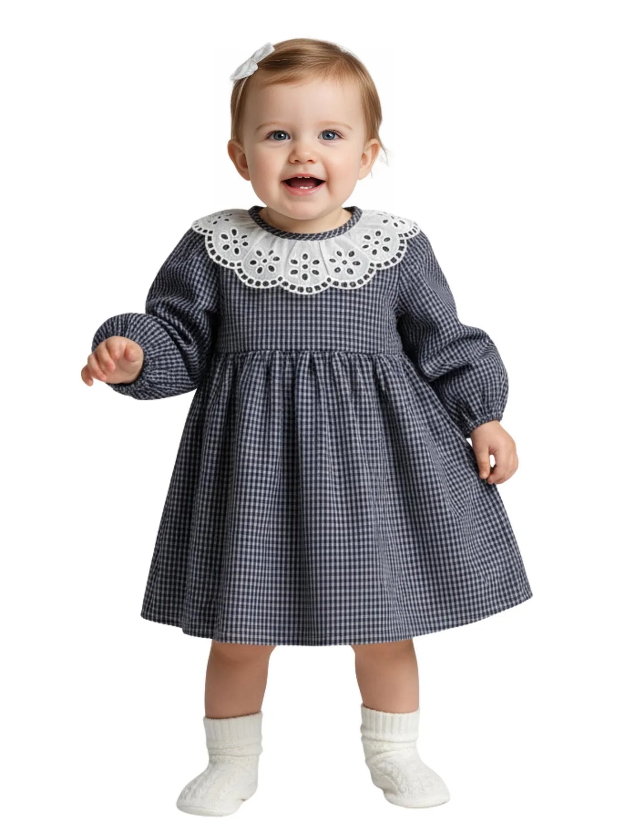Baby wearing a checkered dress with a white collar on a white background