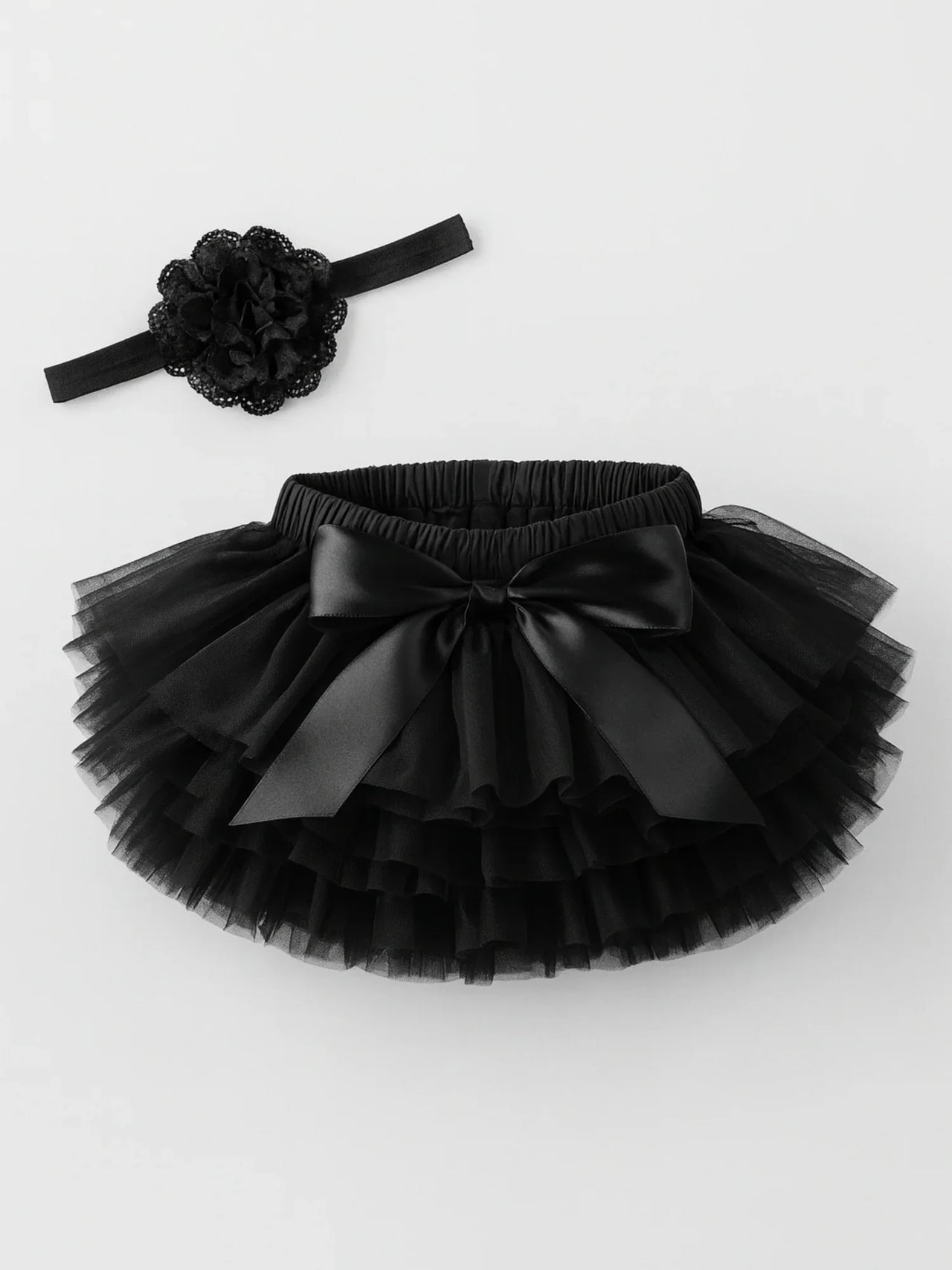 Black tutu skirt with matching headband on a white background