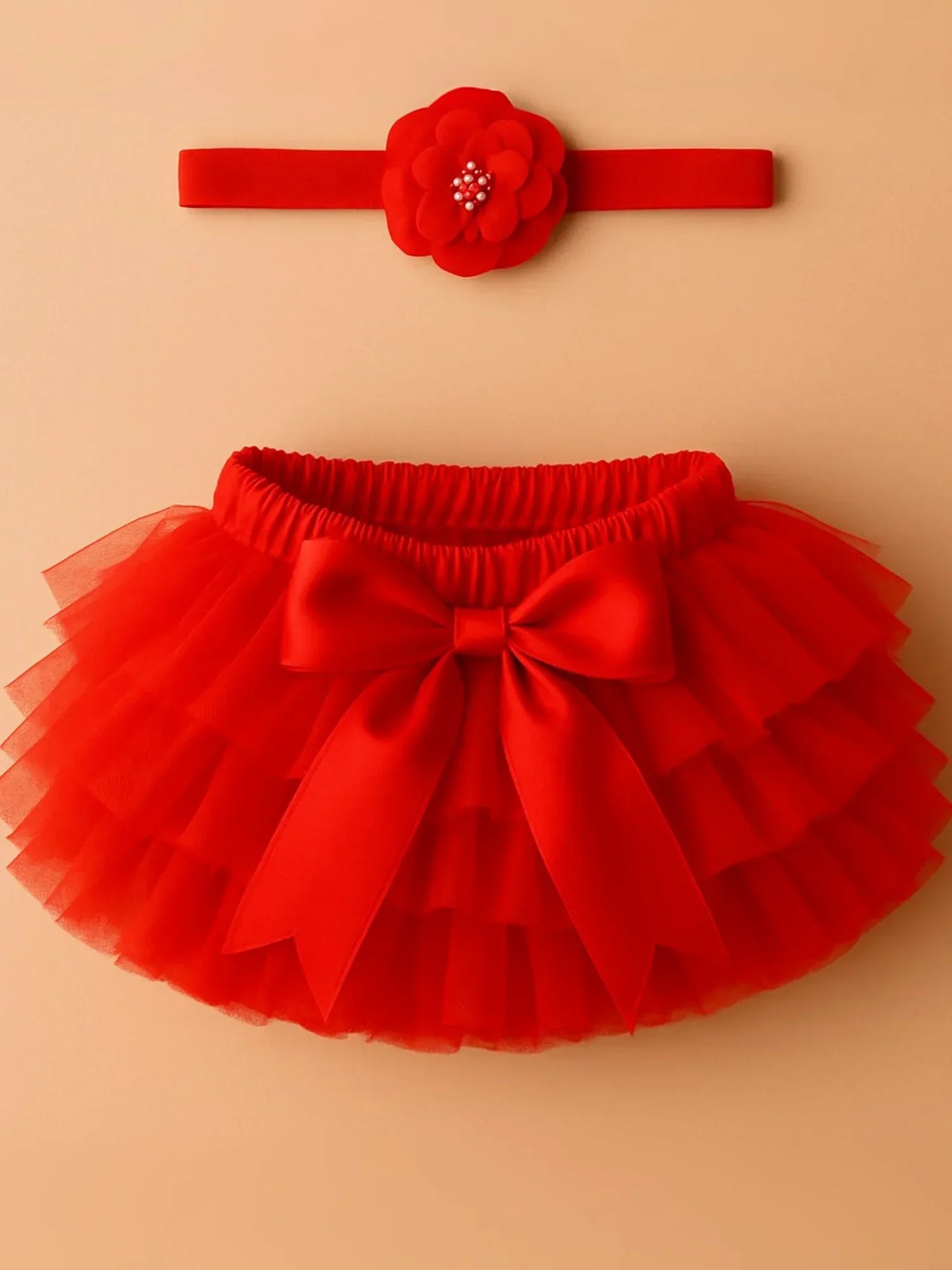 Red tutu skirt and headband set on a beige background
