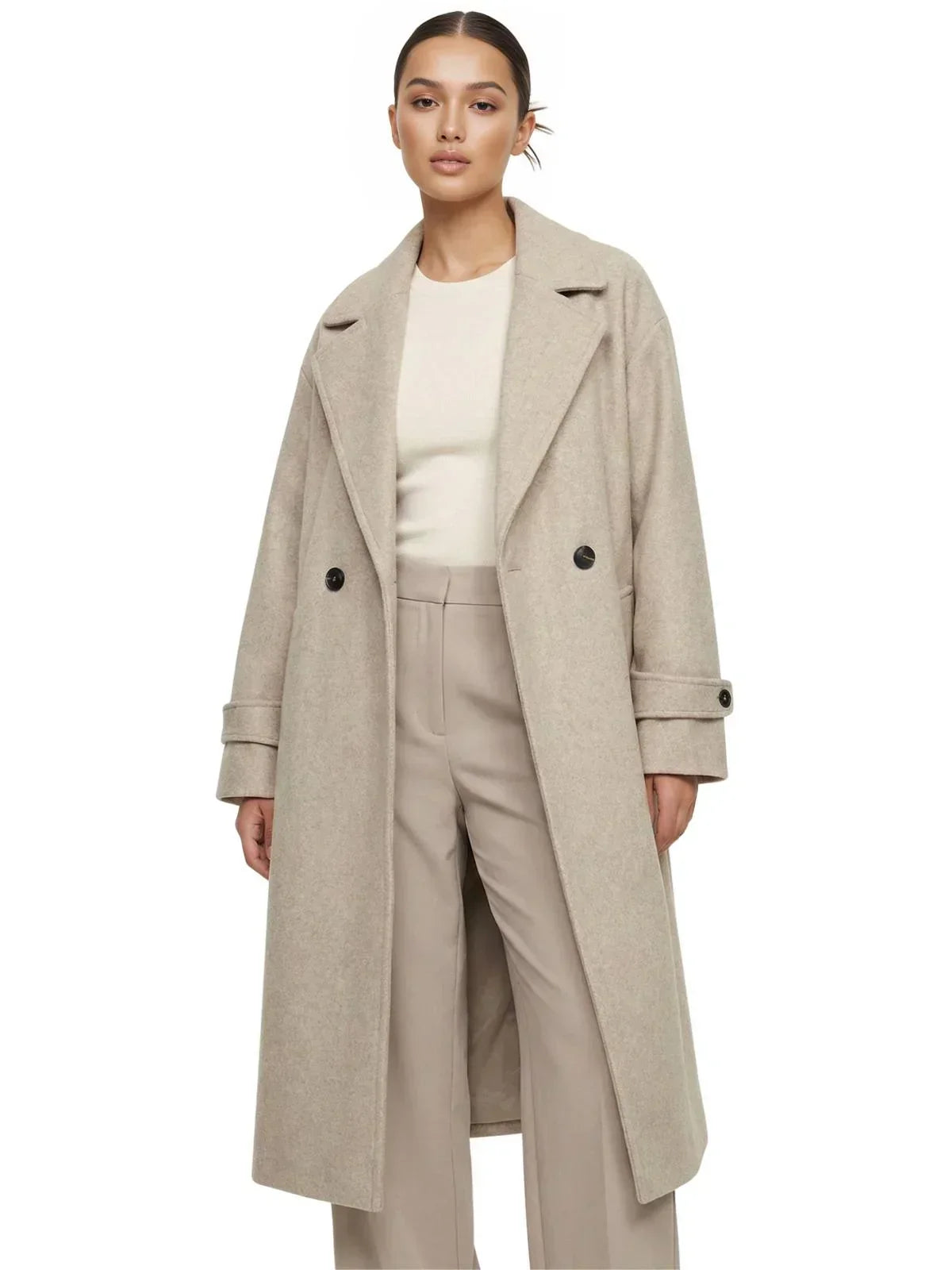 Woman wearing a long beige oversized double breasted coat with pockets and turn down collar on a white background.