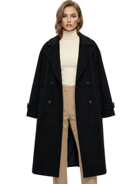 Thumbnail for Woman wearing a long black oversized double breasted coat with pockets and turn down collar on a white background.