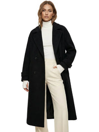 Thumbnail for Woman wearing a long black oversized double breasted coat with pockets and turn down collar on a white background.
